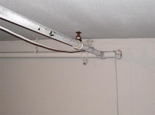 Power cable running across the ceiling on a water pipe